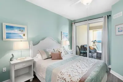 a bedroom with a bed with a white bedspread at Grand Panama 1806 in Panama City Beach