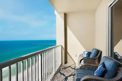 a balcony with two chairs and a view of the ocean at Grand Panama 1806 in Panama City Beach