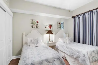 two beds in a bedroom with white walls at Grand Panama 1806 in Panama City Beach