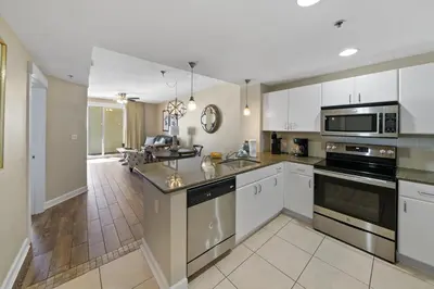 a kitchen with white cabinets and stainless steel appliances at Grand Panama 2004 in Panama City Beach
