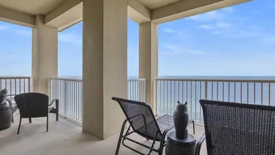 a cat sitting on a balcony looking out at the ocean at Grand Panama 2009 in Panama City Beach