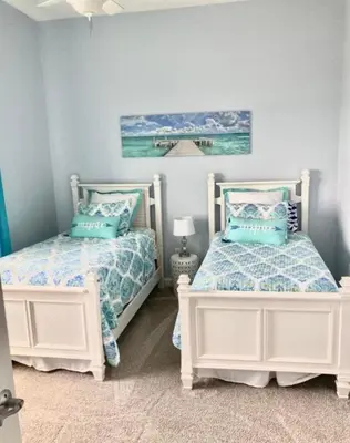 two beds in a bedroom with blue walls at Grand Panama 2009 in Panama City Beach