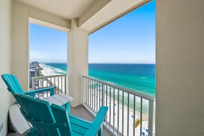 a balcony with two blue chairs and the ocean at Grand Panama 2009 in Panama City Beach