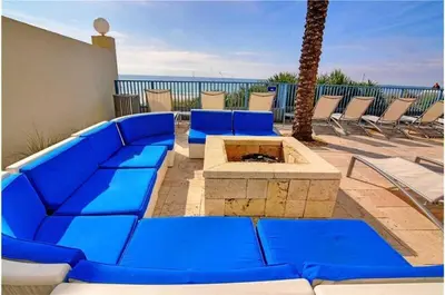 a blue couch and a fire pit on a patio at Sterling Breeze 202 in Panama City Beach