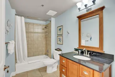 a bathroom with a sink and a tub and a toilet at Sterling Breeze 202 in Panama City Beach