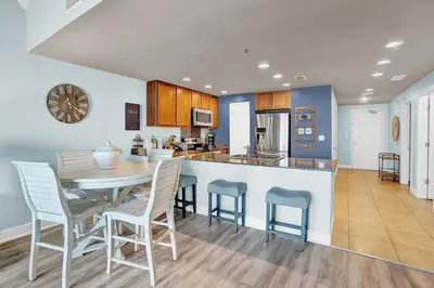 a kitchen and dining room with a table and chairs at Sterling Breeze 202 in Panama City Beach