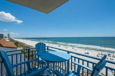 a balcony with blue chairs and a view of the beach at Sterling Breeze 401 in Panama City Beach