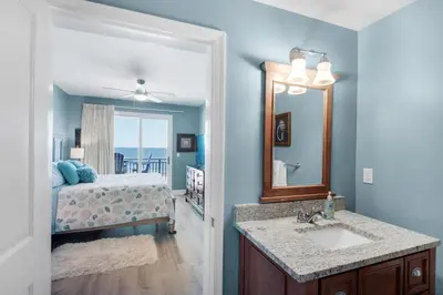 a bathroom with a sink and a bedroom with a bed at Sterling Breeze 401 in Panama City Beach
