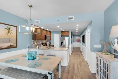 a kitchen with blue walls and a wooden table at Sterling Breeze 401 in Panama City Beach