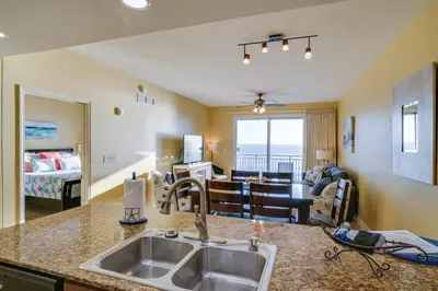a kitchen with a sink and a living room at Sterling Breeze 406 in Panama City Beach