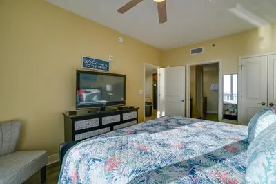 a bedroom with a bed and a flat screen tv at Sterling Breeze 406 in Panama City Beach