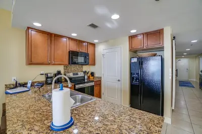a kitchen with a sink and a black refrigerator at Sterling Breeze 406 in Panama City Beach