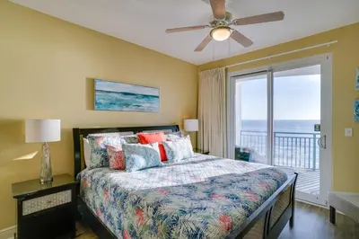 a bedroom with a bed with a view of the ocean at Sterling Breeze 406 in Panama City Beach