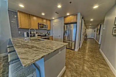 a kitchen with a counter top and a refrigerator at Sterling Breeze 1506 in Panama City Beach