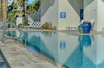 a swimming pool with chairs next to a building at Sterling Breeze 1506 in Panama City Beach