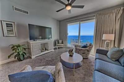 a living room with a tv and a couch and a table at Sterling Breeze 1506 in Panama City Beach