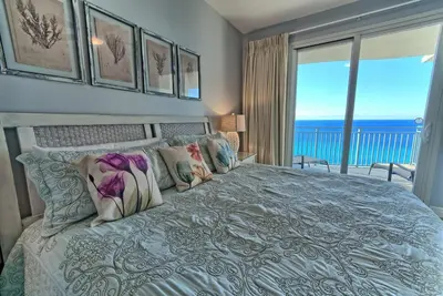 a bedroom with a bed with a view of the ocean at Sterling Breeze 1506 in Panama City Beach