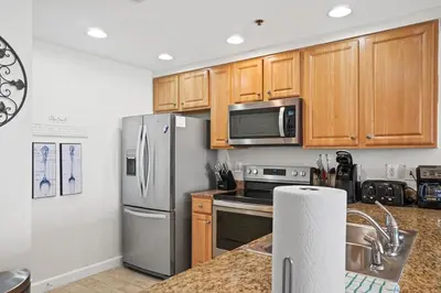 a kitchen with stainless steel appliances and wooden cabinets at Splash 707E in Panama City Beach