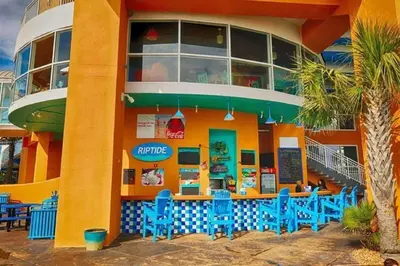 a restaurant with blue chairs in front of a building at Splash 707E in Panama City Beach