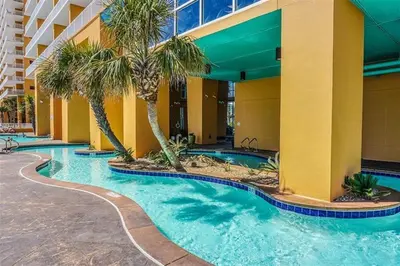 a swimming pool with palm trees in a hotel at Splash 707E in Panama City Beach