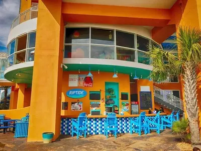a restaurant with blue chairs in front of a building at Splash 903W in Panama City Beach