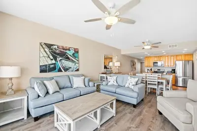 a living room with blue couches and a table at Splash 903W in Panama City Beach