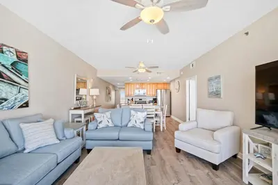 a living room with blue couches and a ceiling fan at Splash 903W in Panama City Beach