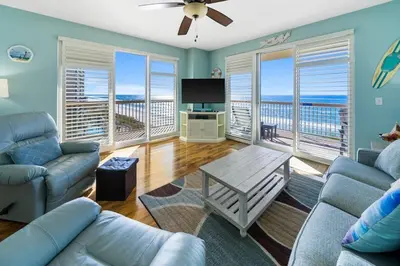 a living room with a couch and a table and a television at Sunrise Beach 801 in Panama City Beach