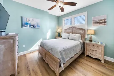 a bedroom with a bed and a ceiling fan at Sunrise Beach 801 in Panama City Beach