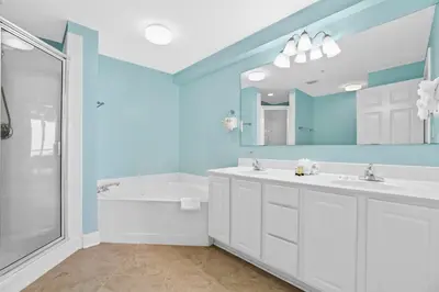 a bathroom with two sinks and a tub and a mirror at Sunrise 1611 in Panama City Beach