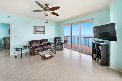 a living room with a couch and a flat screen tv at Sunrise 1611 in Panama City Beach