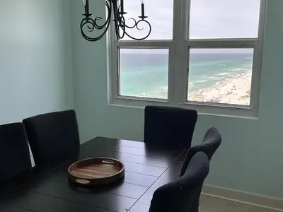 a dining room with a table and a view of the beach at Sunrise 1611 in Panama City Beach