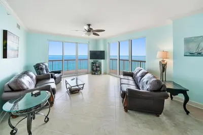 a living room with couches and a view of the ocean at Sunrise 1611 in Panama City Beach