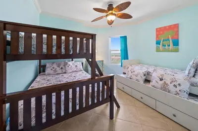 a bedroom with two bunk beds and a ceiling fan at Sunrise 1611 in Panama City Beach
