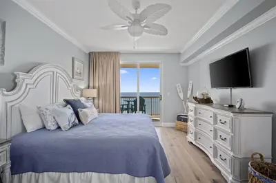 a bedroom with a bed with a ceiling fan and a television at Sunrise 2011 in Panama City Beach