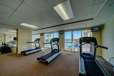 a gym with three treadmills in a building at Sunrise 2011 in Panama City Beach