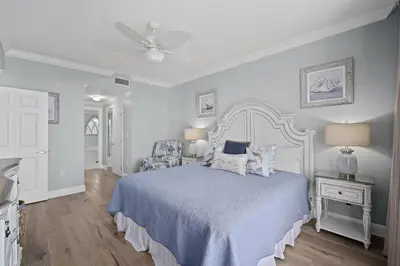 a white bedroom with a bed and a ceiling fan at Sunrise 2011 in Panama City Beach