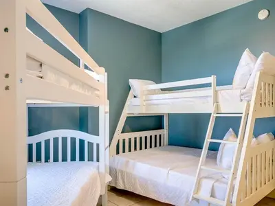 two bunk beds in a room with blue walls at Sunrise 2401 in Panama City Beach