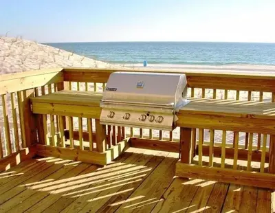 a grill sitting on a wooden bench on the beach at Sunrise 2401 in Panama City Beach