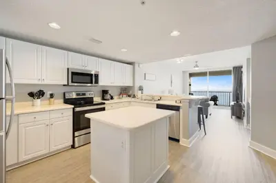 a large kitchen with white cabinets and a kitchen island at Gulf views, beachfront, Majestic Beach Resort in Panama City Beach