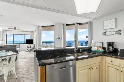 a kitchen with a view of a living room at Aquavista E406 in Panama City Beach