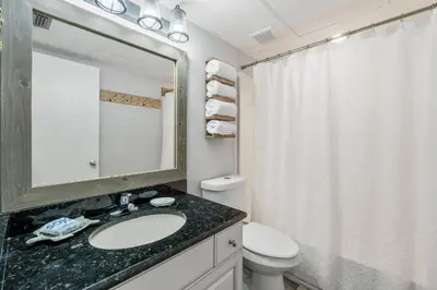 a bathroom with a sink and a toilet and a mirror at Aquavista E406 in Panama City Beach