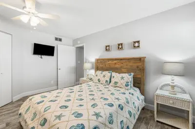 a bedroom with a bed and a ceiling fan at Aquavista E406 in Panama City Beach