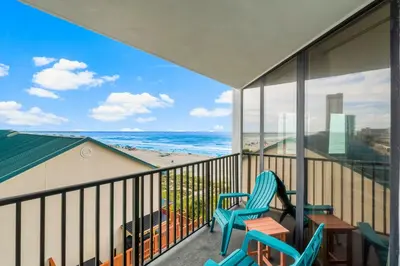 a balcony with two chairs and a view of the beach at Aquavista E406 in Panama City Beach