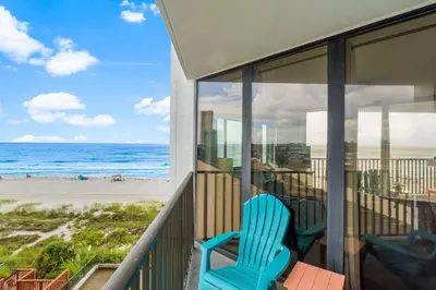 a blue chair sitting on a balcony overlooking the beach at Aquavista E406 in Panama City Beach