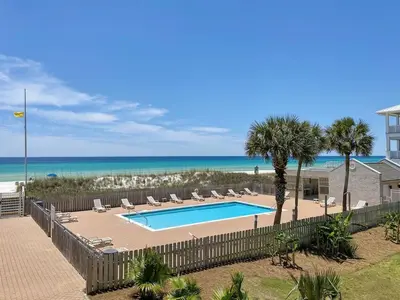 a swimming pool with chairs and the beach at Ramsgate 22 Premium Quality One level Fully Renovated in Panama City Beach