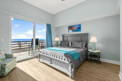 a bedroom with a bed and a view of the ocean at Tidewater Resort! Ground Floor! Free Beach Chairs! by Dolce Vita Getaways PCB in Panama City Beach