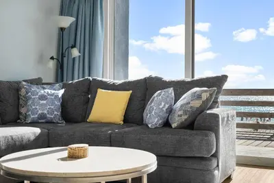 a living room with a couch and a table at Tidewater Resort! Ground Floor! Free Beach Chairs! by Dolce Vita Getaways PCB in Panama City Beach