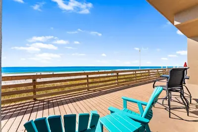 a balcony with chairs and a view of the beach at Tidewater Resort! Ground Floor! Free Beach Chairs! by Dolce Vita Getaways PCB in Panama City Beach