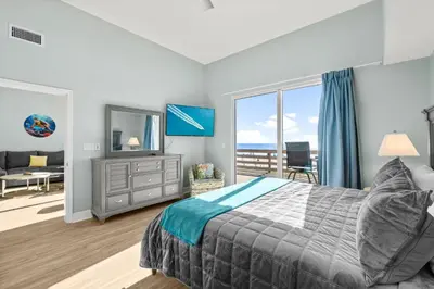a bedroom with a bed and a view of the ocean at Tidewater Resort! Ground Floor! Free Beach Chairs! by Dolce Vita Getaways PCB in Panama City Beach
